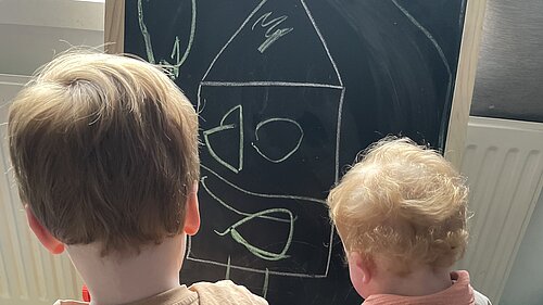 Kids drawing on chalkboard